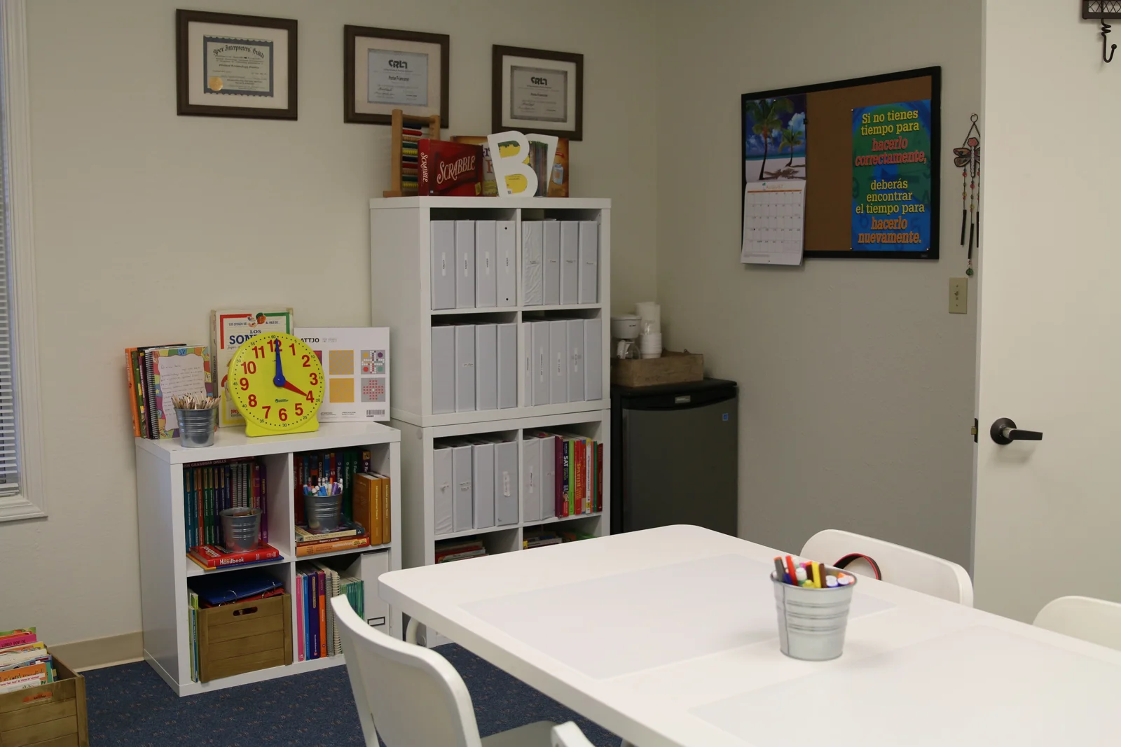 Study table beside bookshelves and Spanish learning resources