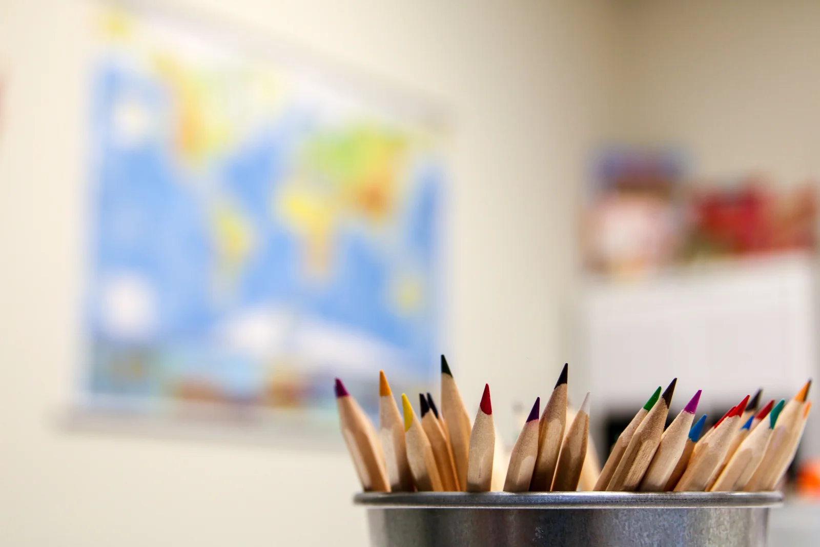 Colored pencils with a world map in the background